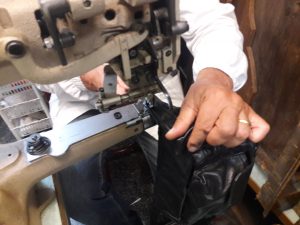 20170831_184143 Giulio al lavoro sulle rifiniture di un marsupio in pelle nappata nera